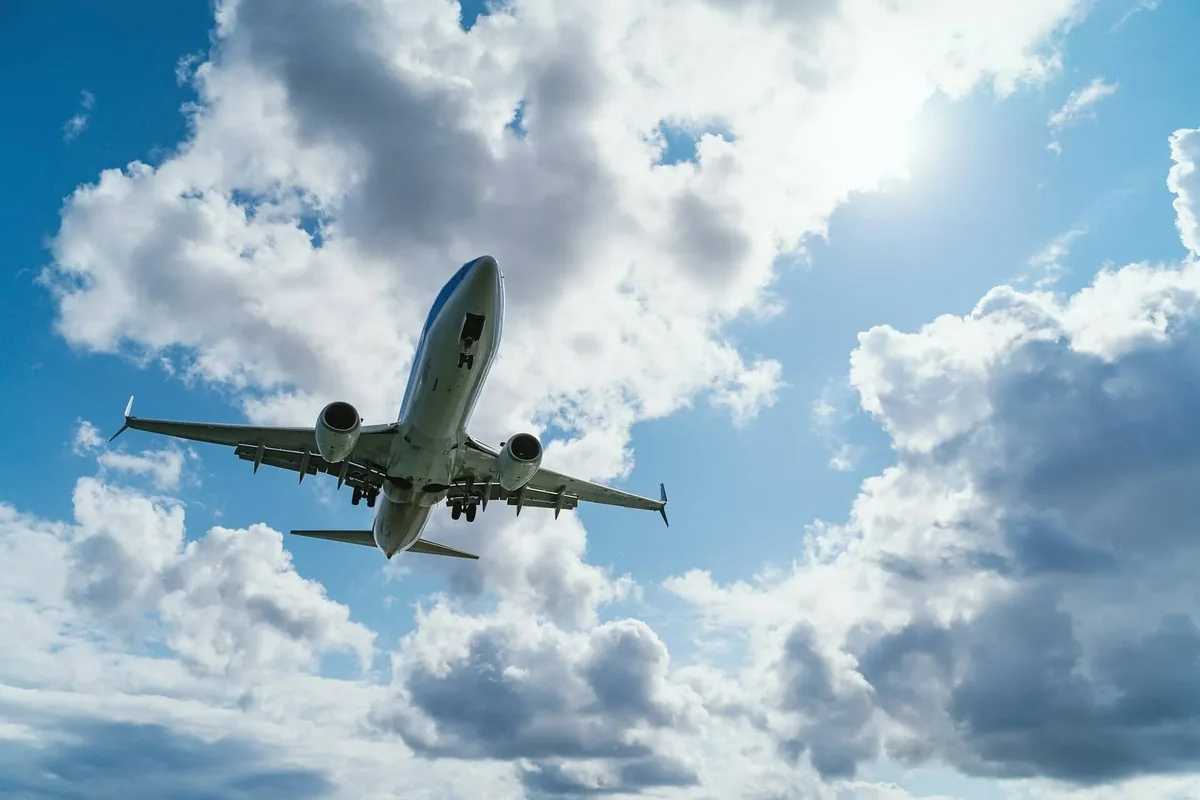 Passagerarflyg på väg in för landning mot en molnig himmel