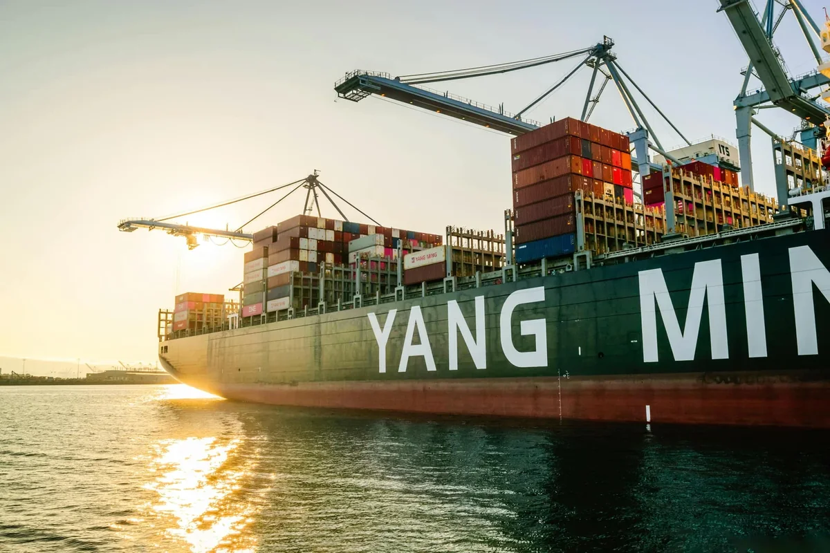 Containerfartyg från Yang Ming vid kaj i motljus
